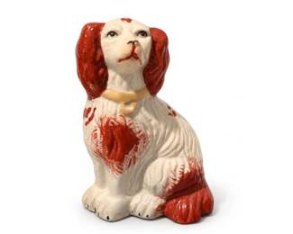 Staffordshire-style ceramic spaniel dog figurine
Condition: Good
Single seated ceramic spaniel-type dog figurine with white body, red-brown painted ears and patches, and a collar detail. The styling closely resembles Staffordshire-style mantel dogs / spaniels.