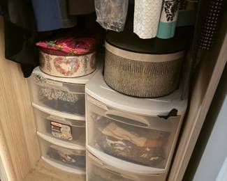 Assorted Closet Storage Organizers Lot: 2 Plastic Drawer Towers and 2 Round Hat Boxes
Condition: Good
Closet storage lot shown in place: two curved-front translucent plastic drawer units on the closet floor, with two round decorative storage/hat boxes sitting on top. Clothes are hanging above. Condition appears used but serviceable from the visible side; no major breaks are obvious in the photo, but full-condition review would require checking the sides, drawer slides, lids, and any odors or stains.