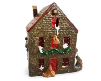 Ceramic Christmas Village House with Stone-Textured Walls and Green Garland
Condition: Good
Ceramic decorative holiday house with brown stone-textured exterior, red windows and door, green garland across the front, snow accents, and a chimney. Appears to be a Christmas village-style collectible or tabletop decor piece.