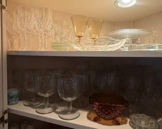 Amber and clear pressed glass bowl with scalloped rim
Condition: Good
Small decorative amber/clear glass bowl or shallow centerpiece dish with a flared/scalloped rim, likely vintage or mid-century style. The image shows mixed glassware on a cabinet shelf; this appears to be the most distinct standalone salable object visible.