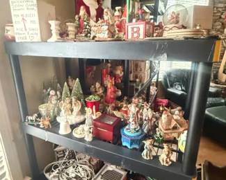 Assorted Christmas figurines and ornaments display lot
Condition: Good
Large mixed assortment of Christmas/holiday miniatures and ornaments displayed on a shelving unit, including Santa figures, snowmen, angels, small houses, trees, and decorative blocks/boxes. Secondary items such as cords and shelving are not part of the salable lot.