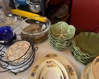 Vintage ceramic servingware lot with green leaf dishes and floral oval platters
Condition: Good
Assorted decorative servingware lot visible on a tabletop/shelving area, including several stacks of green leaf-molded ceramic dishes/plates and cream oval floral platters/bowls. Useful as display or serving pieces; likely a mixed estate-sale grouping rather than a factory-matched set.
