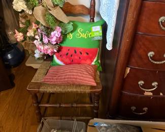 Vintage wooden ladder-back side chair with woven rush seat
Condition: Good
Wooden ladder-back side chair with turned front posts, woven rush-style seat, and medium-brown finish. Visible age/use wear appears light to moderate. Decorative pillow and floral arrangement are separate objects and not part of the chair.