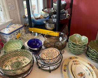 Vintage ceramic cabbage-leaf bowl set
Condition: Good
Primary salable object appears to be a group of green ceramic cabbage/leaf-shaped bowls stacked on the right side of the table, with additional mixed serving pieces nearby. Overall condition cannot be fully verified from the photo; visible pieces appear used but intact at a glance.