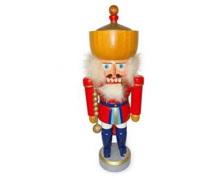 Wooden German-style nutcracker king soldier figurine
Condition: Good
Single wooden nutcracker king/soldier figurine with painted red sleeves, blue legs, gold crown/hat, white faux beard, and round base. The figure appears in used condition with visible handling wear appropriate to a decorative holiday item. No packaging shown.