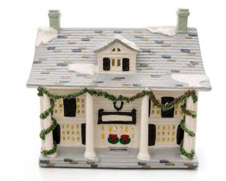 Ceramic Christmas village house with porch columns, garland, and snow-covered roof
Condition: Good
White-and-gray ceramic/porcelain-style holiday house with snow accents on the roof, twin chimneys, front porch with columns, evergreen garland, black shutters, and a small 'WELCOME' sign by the front steps.