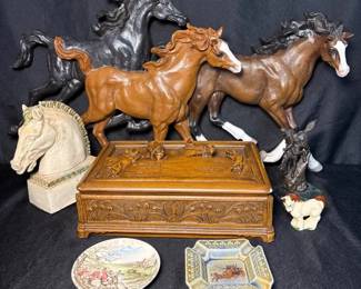 carved wooden decorative box surrounded by several equestrianthemed sculptures
