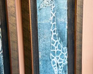 Framed Contemporary Giraffe Artwork A striking and unique piece of contemporary wall art featuring a stylized giraffe in dramatic shades of blue, gray, and white. The artwork has a beautifully textured, almost abstract appearance that gives the piece depth and visual interest.