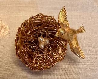 vintage gold-tone Jeanne bird-and-nest brooch featuring an intricately twisted wire nest holding three small faux pearl eggs.