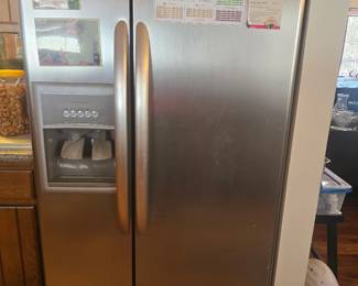 Kenmore Elite stainless-steel side-by-side refrigerator/freezer with in-door ice & water dispenser. Full-size kitchen appliance with visible cosmetic wear consistent with use. Buyer responsible for removal. Working condition/as is