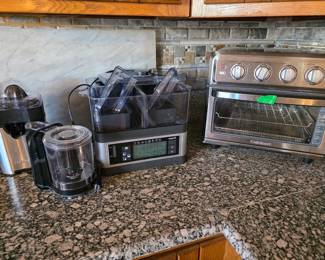 Collection includes a Cuisinart citrus juicer, compact food processor/chopper, Vianté Intellisteam digital multi-compartment food steamer, and Cuisinart countertop convection/toaster oven. Stainless-steel and black finishes with removable components and accessories.