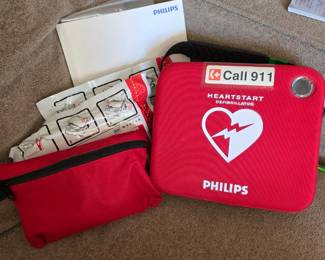 Philips HeartStart AED / automated external defibrillator with carrying case, manuals and accessories. Older unit; electrode pads shown are expired and unit has not been certified or tested for current emergency use. Sold as-is for replacement parts, training, collection or refurbishment as appropriate.