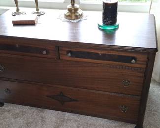 vintage wooden chest of drawers featuring a distinctive diamond-shaped inlay on the lower drawer.