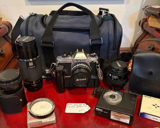 J58 - $120. Nikkon FG 35mm SLR Film Camera. Lens and Accessory Lot. Camera is untested.