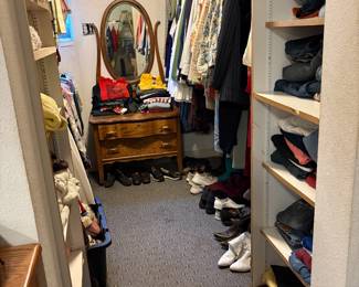 Dresser with women's clothes. The closet on the left side has two levels of clothing. Entry shelves hold pants, sweaters and sweatshirts. Shoes.