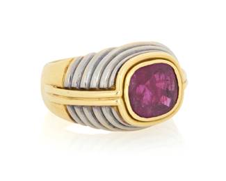 19 An 18K Bi-Color Gold and Ruby Ring Of a tiered design centering a cushion-cut ruby measuring approximately 8.38 x 7.75 x 4.99 mm, with French assay and makers marks Size: 6 13.7 grams gross Estimate: $3,500 - $5,500