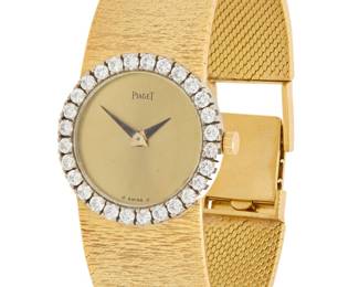 305 Piaget: An 18K Bi-Color Gold and Diamond Watch Dial: 19.00 mm, round gold diamond with no hour markers, encircled by round diamonds weighing 1.10 carats Case: 24.10 mm Case number: MG 9982, 90141 Closure: textured gold bracelet with notched clasp Signed: dial, movement Bueche-Girod Inner circumference: 6 1/2 - 7 in. 64.3 grams gross Estimate: $8,000 - $12,000