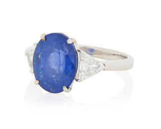 183 An 18K White Gold, Sapphire and Diamond Ring Centering an oval sapphire weighing approximately 6.10 carats flanked by two triangular-cut diamonds weighing approximately 0.90 carats size: 6 5.3 grams gross Estimate: $3,500 - $5,500