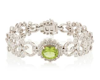104 An 18K White Gold, Peridot and Diamond Bracelet Centering an oval peridot weighing approximately 3.56 carats, accented by ornate foliate links set with round diamonds weighing approximately 3.60 carats Length: 7 in., Width: 3/4 in. 33.9 grams gross Estimate: $4,500 - $6,500