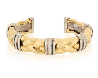95 Bulgari: An 18K Gold, Sterling Silver and Steel Cuff Featuring a yellow gold braided design accented by triple bands of sterling silver, signed Bulgari Inner Circumference: 5 1/2 in., Gap: 1 in. 57.0 grams gross Estimate: $4,500 - $6,500