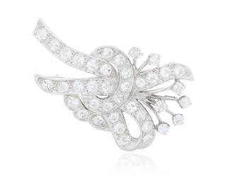 246 A Platinum and Diamond Brooch Of a ribbon design featuring old European-cut diamonds weighing approximately 6.60 carats Measures: 2 x 1 1/4 in. 19.3 grams gross Estimate: $1,500 - $2,000
