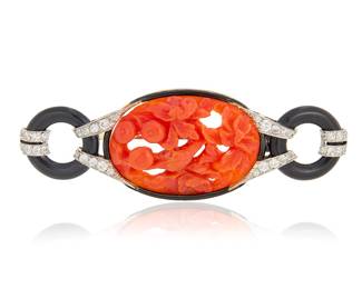 127 An Art Deco Platinum, Coral and Onyx Brooch Centering a carved red coral featuring fruit, bird and floral design, accented by round onyx discs finished with single-cut diamonds Measures: 2 3/4 x 1 in. 15.6 grams gross Estimate: $6,000 - $8,000
