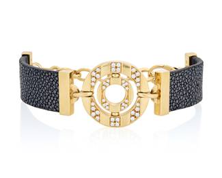 97 Bulgari: An 18K Gold, Diamond and Shagreen 'Astrale' Bracelet Centering two nested discs accented by round diamonds weighing approximately 0.65 carat, flanked by two black shagreen leather straps, signed Bulgari with Italian workshop marks Length: 6 1/2 - 8 1/2 in. 48.2 grams Estimate: $3,500 - $5,500
