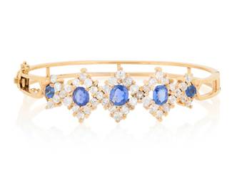 159 An 18K Gold, Sapphire and Diamond Bracelet Of a hinged design featuring kite shaped motifs set with five oval cut sapphires, accented by old mine-cut and round diamonds weighing approximately 4.10 carats Inner Circumference: 7 in. 17.8 grams gross Estimate: $5,000 - $7,000