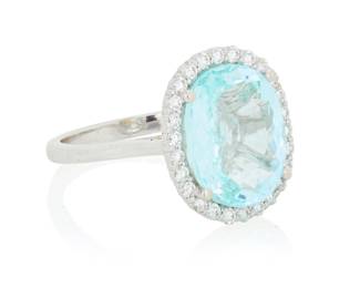 38 An 18K White Gold, Paraiba Type Tourmaline and Diamond Ring Centering an oval Paraiba type tourmaline weighing approximately 5.08 carats, encircled by round diamonds Size: 6 1/4 4.5 grams gross Accompanied by a GIA Report numbered #1206812167, dated January 16,2020, stating the stone is a natural copper bearing Tourmaline. Estimate: $6,000 - $8,000