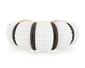 90 David Webb: An 18K Gold, Coral and Enamel Cuff Featuring carved domed elements of white coral, accented by bands of black enamel, with two hinged ends, signed Webb Measures: 5 3/4 in., Gap: 5/8 in. 203.6 grams gross Estimate: $30,000 - $50,000
