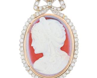 120 A 14K Bi-Color Gold and Sardonyx Cameo Pendant Featuring an ornate ribbon frame set with old mine-cut diamonds weighing approximately 2.75 carats, centering a carved sardonyx cameo, with artist etched signature Measures: 2 1/4 x 1 1/2 in. 17.1 grams gross Estimate: $3,000 - $5,000