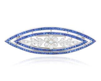 124 A Platinum, Sapphire and Diamond Pin Featuring nested navette style frames featuring French-cut sapphires, centering a flower motif set with single-cut diamonds Measures: 2 1/2 x 3/4 in. 17.1 grams gross Estimate: $3,500 - $5,500