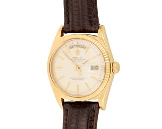 311 Rolex: An 18K Gold 'Datejust President' Watch Dial: 28.00 mm, Round with baton hour markers Case: 35.00 mm Number: 1803 Closure: brown leather strap with gold-plated buckle clasp Signed: dial with original booklet Inner circumference: 7 1/4 - 8 1/2 in. 63.9 grams gross Estimate: $9,000 - $12,000