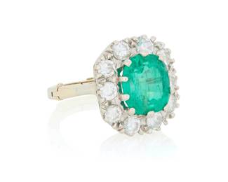232 A 14K White Gold, Emerald and Diamond Ring Centering an octangular-cut emerald weighing approximately 3.20 carats, encircled by 10 round diamonds weighing approximately 1.20 carats Size: 4 1/4 with hinged shank 4.9 grams gross Estimate: $3,500 - $5,500