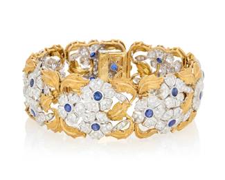 199 An 18K Bi-Color Gold, Sapphire and Diamond Bracelet Featuring floral motif links, accented by single-cut diamonds weighing approximately 6.85 carats, finished with twenty-one round sapphires, signed Italy Length: 7 1/2 in., Width: 7/8 in. 57.3 grams gross Estimate: $7,000 - $10,000