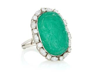 223 A Platinum, Emerald and Diamond Ring Featuring a caved emerald cabochon encircled by round and marquise-shaped emeralds weighing approximately 1.30 carats Size: 7 with sizing band 20.5 grams gross Estimate: $7,000 - $10,000
