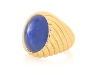 269 Bulgari: An 18K Gold and Star Sapphire Ring Featuring an oval double cabochon star sapphire weighing approximately 27.23 carats, set in a high polish fluted mounted, signed Bulgari, with Italian workshop marks Size: 7 1/4 24.0 grams gross Accompanied by a GIA Report numbered #1242033562, dated August 26, 2026, stating the Sapphire as natural Corundum of Burma origin with No heat enhancements. Estimate: $20,000 - $30,000