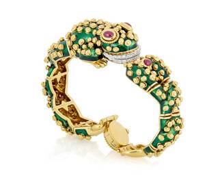 167 David Webb: An 18K Gold, Enamel and Ruby Frog Bracelet Of a leaping frog design accented by dimensional gold spirals, green enamel, round diamonds and finished with oval ruby cabochon eyes and clasp, signed Webb Inner Circumference: 6 3/4 in. 131.5 grams gross Estimate: $35,000 - $55,000