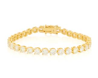 56 A 14K Gold and Diamond Bracelet Of a single line design featuring thirty-three round diamonds weighing approximately 11.79 carats Length: 7 1/2 in. 14.5 grams gross Estimate: $4,800 - $5,500