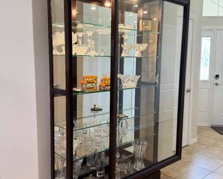 LARGE LIGHTED SLIDING-GLASS CURIO DISPLAY CABINETS — 2 MATCHING Oversized Statement Display Cabinet • Approx. 83 x 46 x 14.5 • Rich Dark Wood Finish • Sliding Glass Front Doors • Glass Side Panels • Full Mirrored Back • Multiple Glass Display Shelves • Interior Display Lighting • Elevated Furniture-Style Base