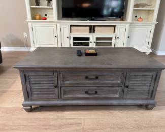 MAGNUSSEN HOME LANCASTER COCKTAIL / COFFEE TABLE: Lancaster Collection • Grey Finish • Weathered Bronze Hardware • • 4 Louvered Storage Doors • 2 Interior Wood Shelves • Approx. 50”W × 28”D × 18.5”H