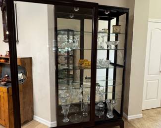 LARGE LIGHTED SLIDING-GLASS CURIO DISPLAY CABINETS — 2 MATCHING Oversized Statement Display Cabinet • Approx. 83 x 46 x 14.5 • Rich Dark Wood Finish • Sliding Glass Front Doors • Glass Side Panels • Full Mirrored Back • Multiple Glass Display Shelves • Interior Display Lighting • Elevated Furniture-Style Base