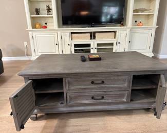 MAGNUSSEN HOME LANCASTER COCKTAIL / COFFEE TABLE: Lancaster Collection • Grey Finish • Weathered Bronze Hardware • • 4 Louvered Storage Doors • 2 Interior Wood Shelves • Approx. 50”W × 28”D × 18.5”H
