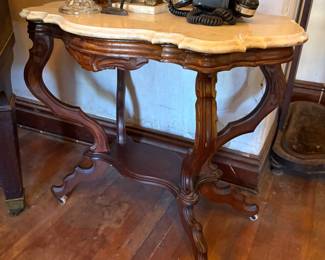 Walnut carved entry table with marble top on casters