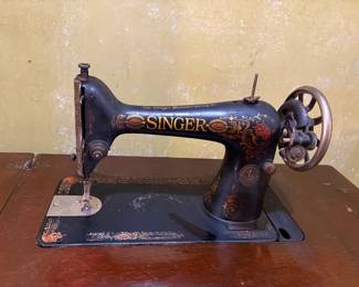 Singer Treddle Sewing machine in fold out cabinet with attachments