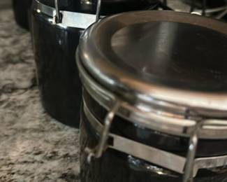 black ceramic storage canisters with metal clamp-top lids