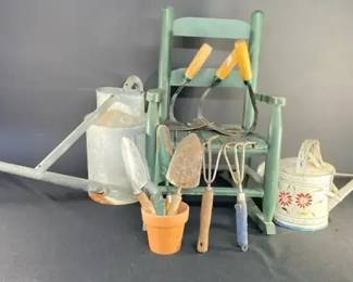 Water Cans Garden Tools, And A Small Rocking Chair