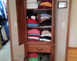 Tall storage cabinet with sweaters