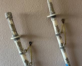 Pair of decorative faux bone samurai katana swords with engraved motifs