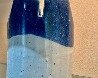 Handmade ceramic base with a speckled white base and a glossy deep blue upper glaze featuring a notch rim
